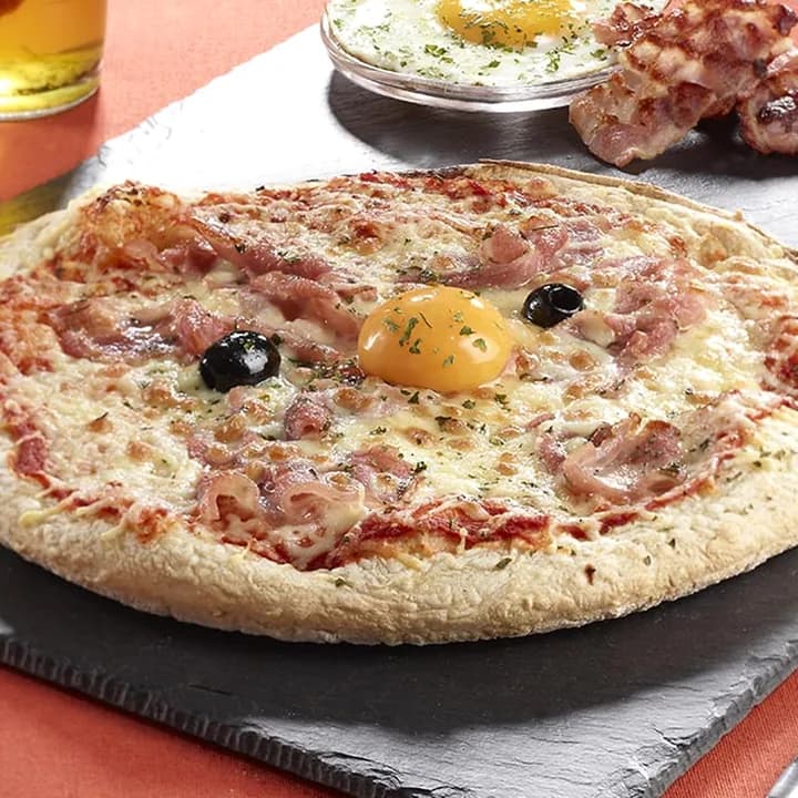 Pizza Londonienne : Bacon, Jaune d'œuf cru, Oignons, Emmental, Mozzarella, Persil, Olives
