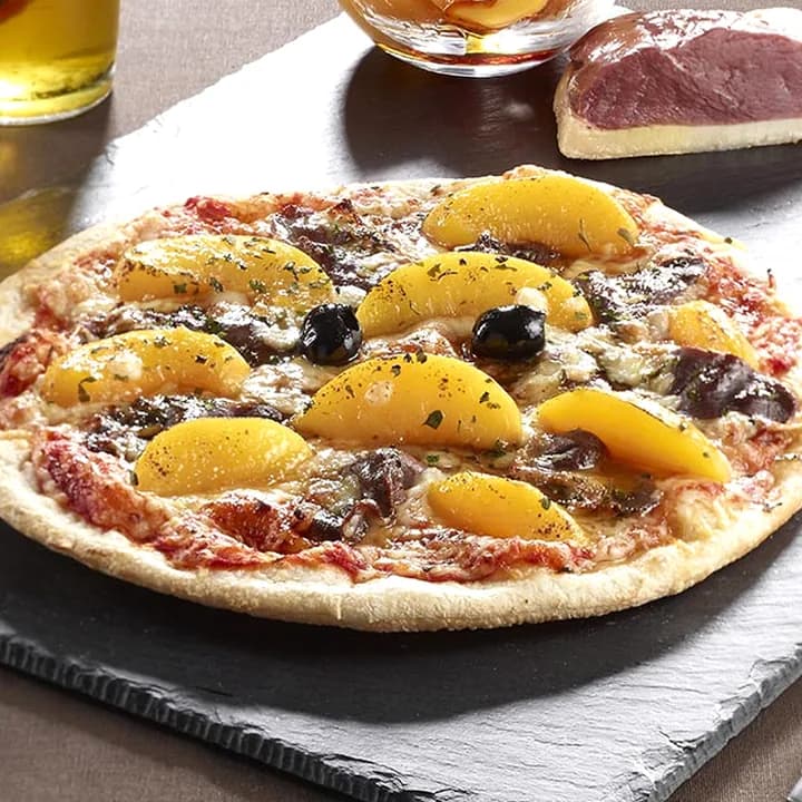 Pizza La Nantaise : Magret de canard, Pêches, Sauce caramel, Emmental, Mozzarella, Persil, Olives